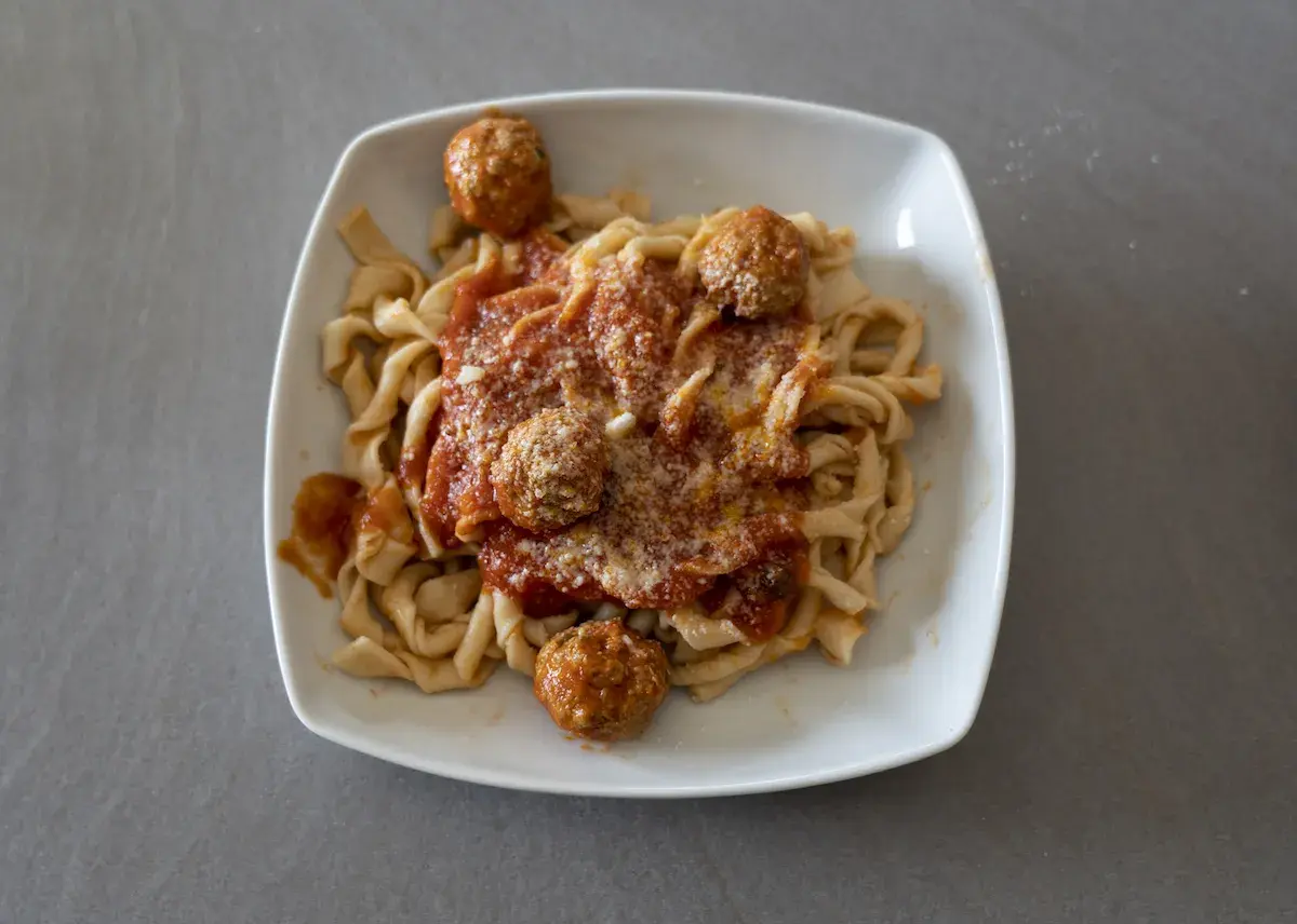 Sagne ncannulate con polpette al sugo, un piatto ricco e saporito, pronto per essere gustato.