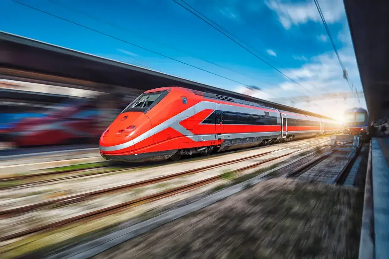 Train rouge vif filant sur les rails, prêt pour un voyage rapide entre Rome et Naples.