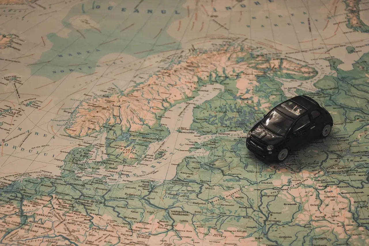 Une petite voiture noire sur une carte d'Europe. Idéal pour une musique à mettre dans sa playlist de road trip.