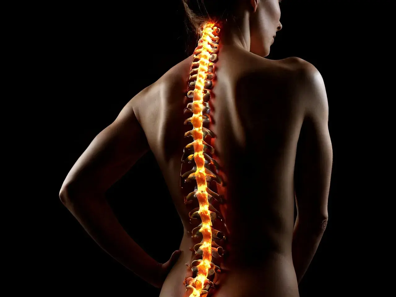 Płonący kręgosłup kobiety, symbolizujący bóle i potrzebę diagnostyki w kinezyterapii i masażu.