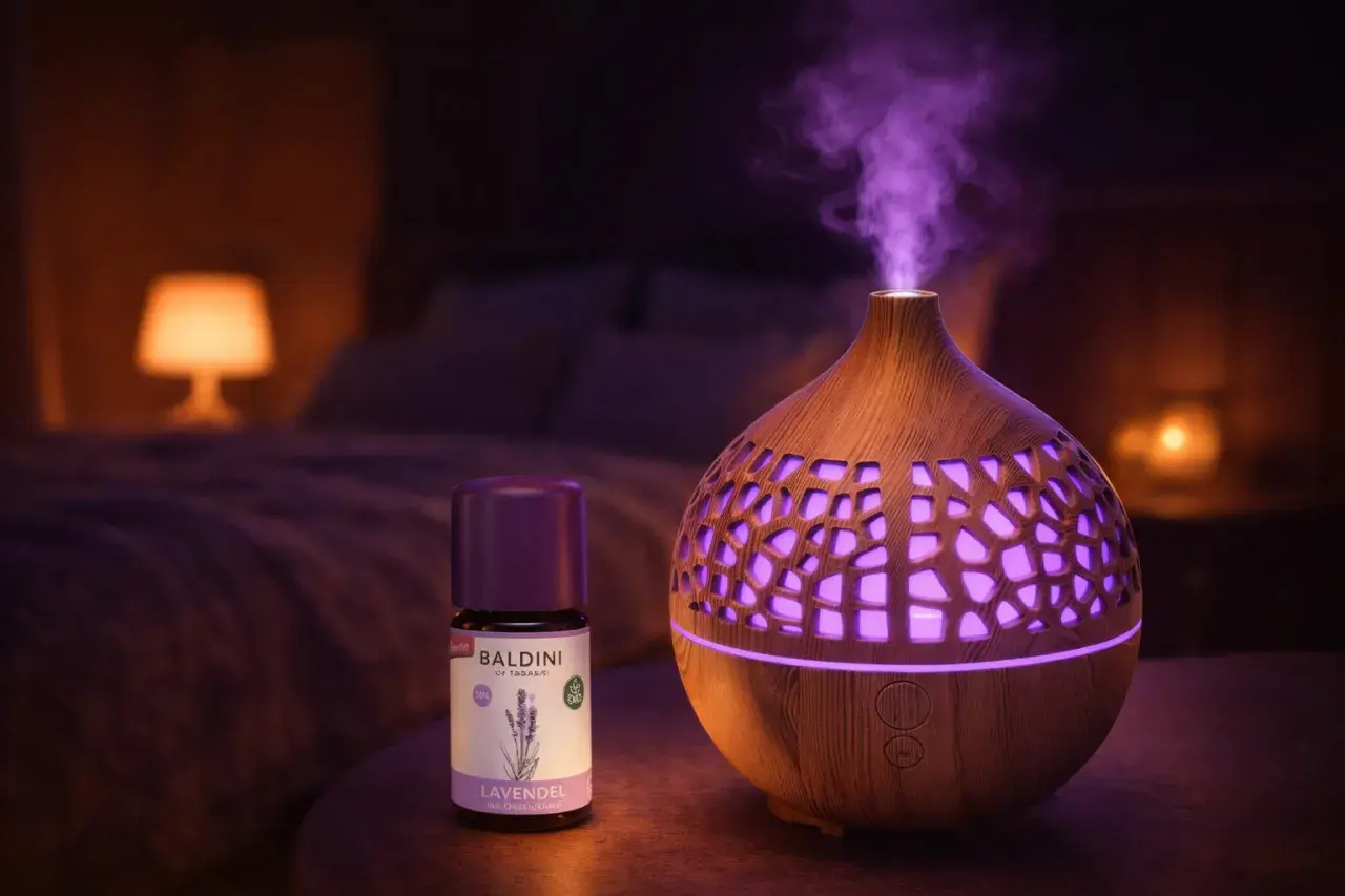 Ein Diffusor verströmt lila Dampf, daneben eine Flasche Baldini Lavendelöl. Perfekt für Lavendel Entspannung im Schlafzimmer.
