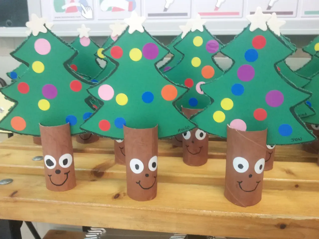 Arbolitos verdes decorados con círculos de colores y estrellas, listos para celebrar el día del árbol.