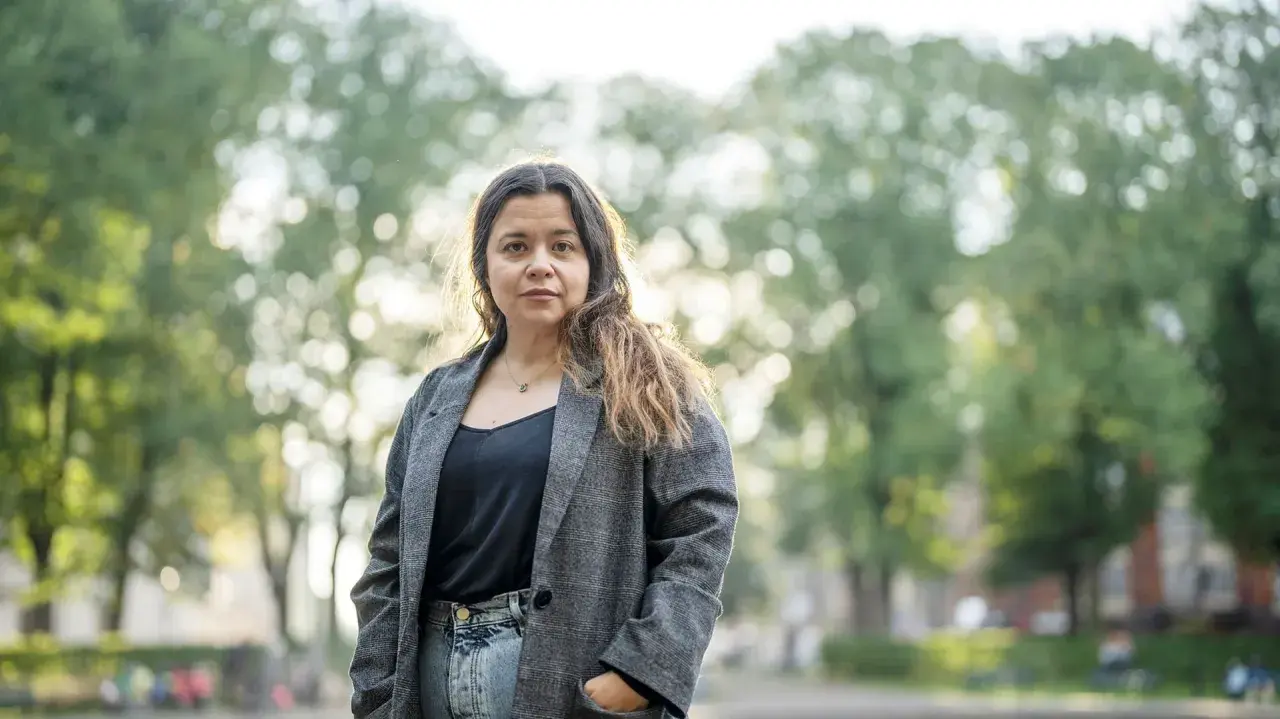 Caroline Ringskog Ferrada-Noli, partner, står utomhus i en park med träd i bakgrunden.