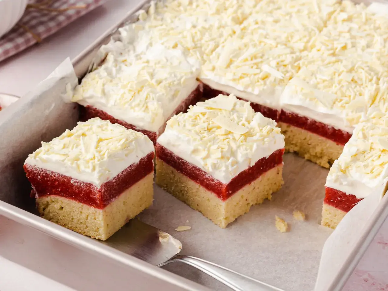 Schneeweiße Sahne und rote Fruchtschicht auf hellem Boden – dieser Frau Holle Kuchen sieht aus wie frisch aus dem Märchen!