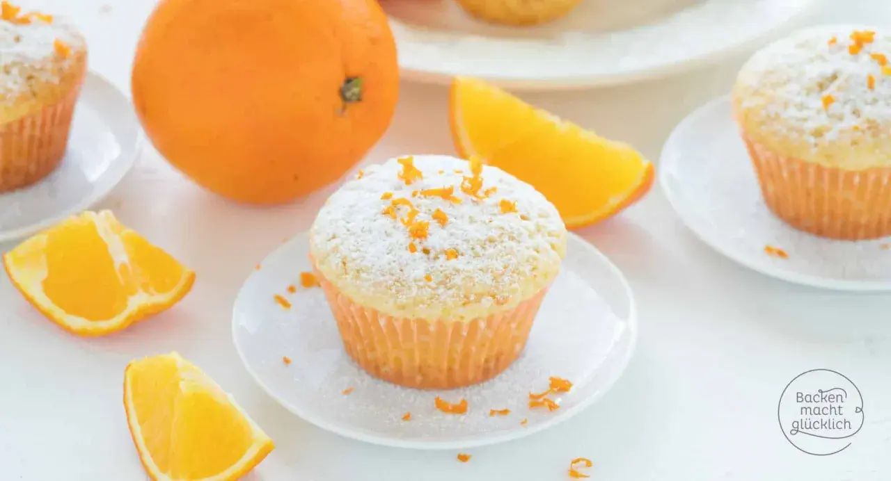 Fanta Muffins mit Puderzucker und Orangenschale, garniert mit frischen Orangenspalten. Ein süßer Genuss!