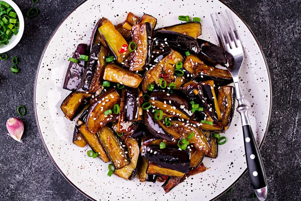 Aubergines laquées, parsemées de sésame et d'oignons verts. Une recette savoureuse pour sublimer ce légume.