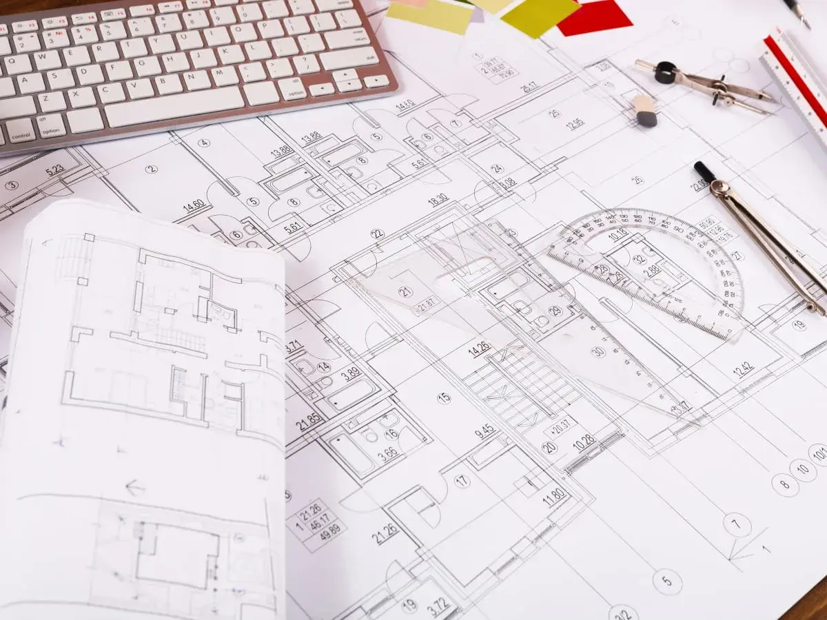 Rzut pokoju z widocznym planem architektonicznym, klawiaturą, cyrklem i linijką.