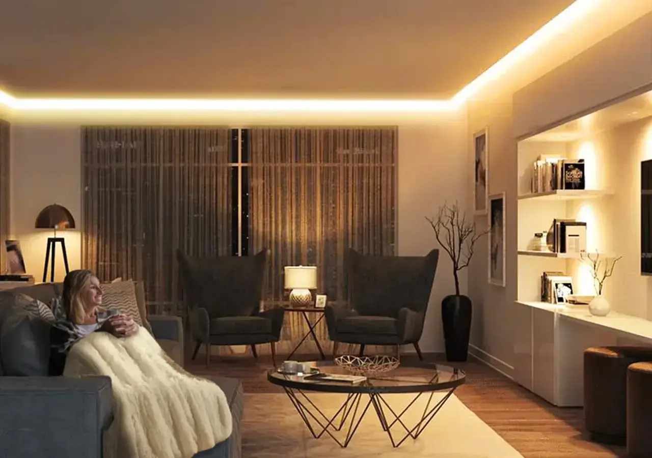 Mujer relajada en sofá con manta, rodeada de cálida iluminación ambiental de 3000k color.