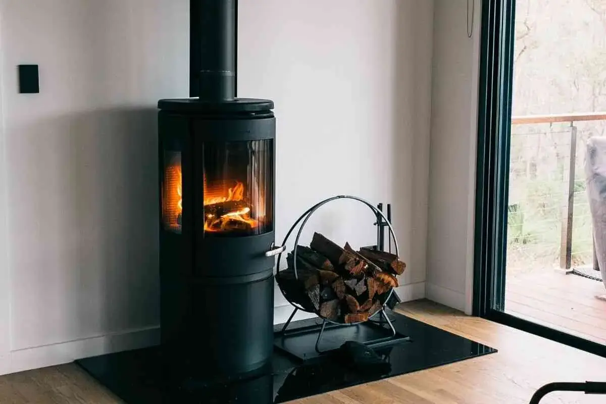 Poêle à bois moderne avec flammes vives et bûches. Une question se pose : peut-on installer un poêle à granule soi même ?