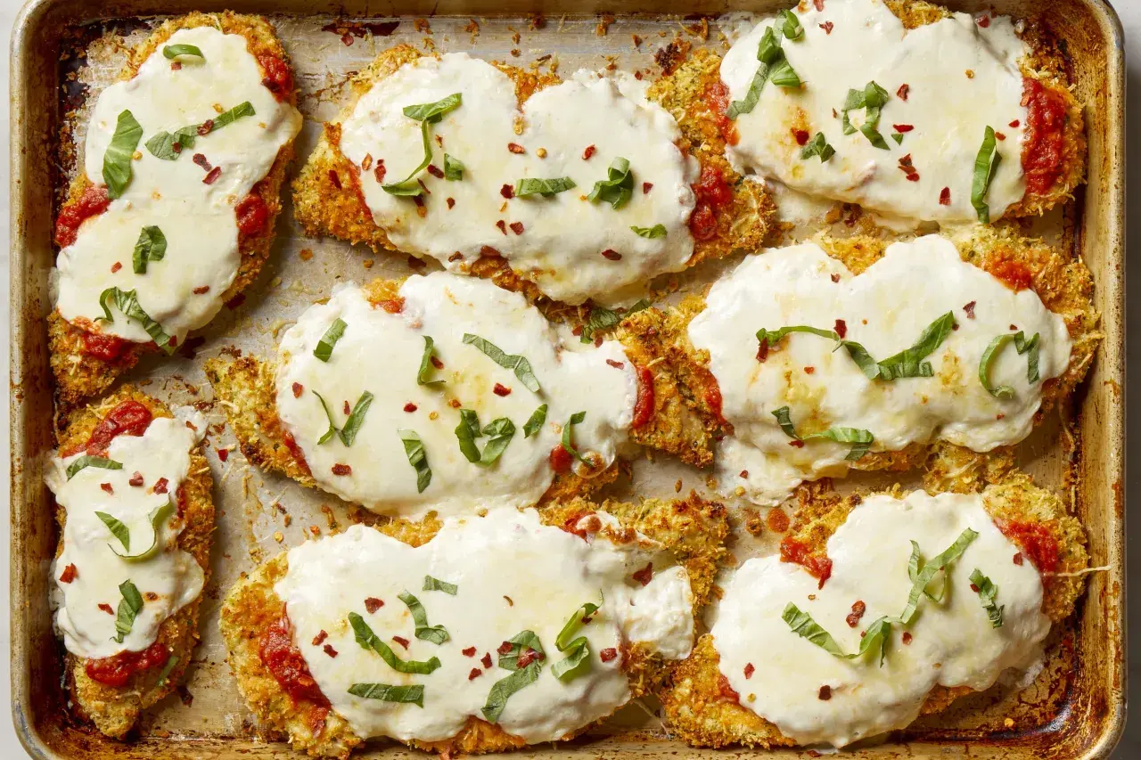 Cotolette di pollo impanate e gratinate con mozzarella filante, salsa di pomodoro e basilico fresco. Un elenco di cibi deliziosi pronti per essere gustati.