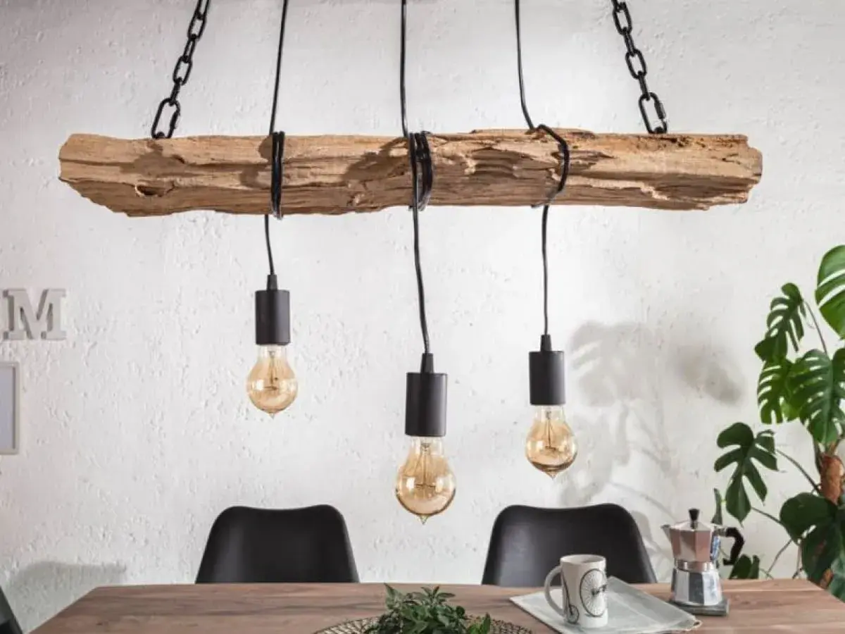 Drewniany żyrandol diy z trzema żarówkami w stylu industrialnym, wiszący na łańcuchach nad stołem.