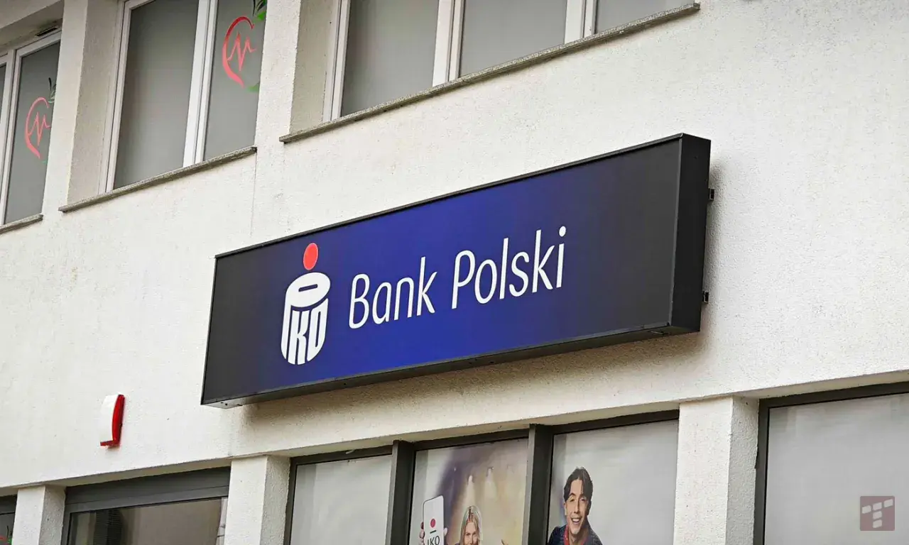 Logo Banku Polskiego na niebieskim tle. Obok widoczny czerwony sygnalizator. W tle okna z grafikami, być może ankieta AML.
