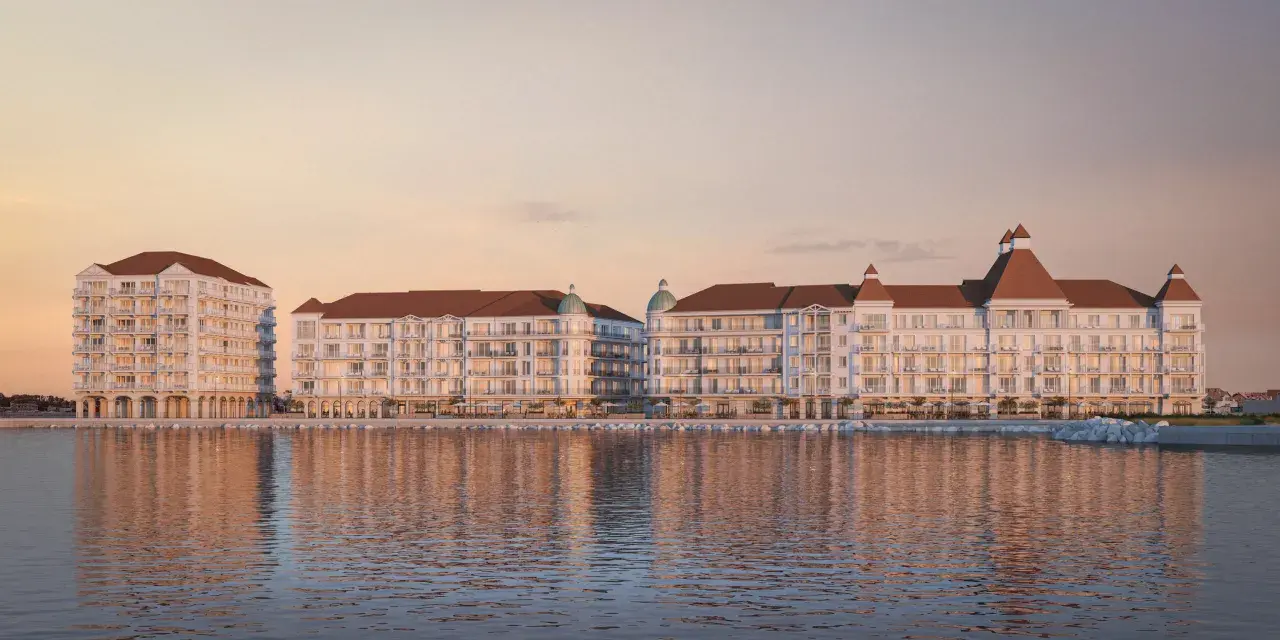 Eleganckie budynki nad wodą, z tarasami i dachami w kolorze cegły. To wizualizacja mariny royale darłowo, idealnego miejsca na wypoczynek.