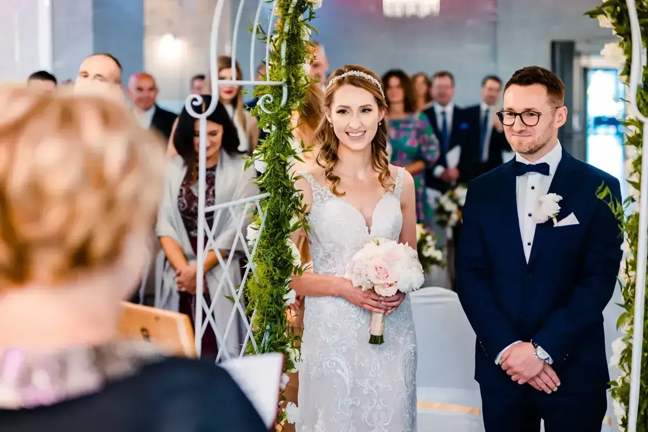 Para wzięła ślub cywilny po rozwodzie. Panna młoda w białej sukni z bukietem, pan młody w granatowym garniturze.
