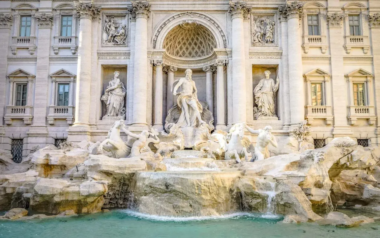 Fontana di Trevi: maestosa opera barocca con Nettuno al centro, cavalli marini e cascate d'acqua. Una descrizione iconica di Roma.