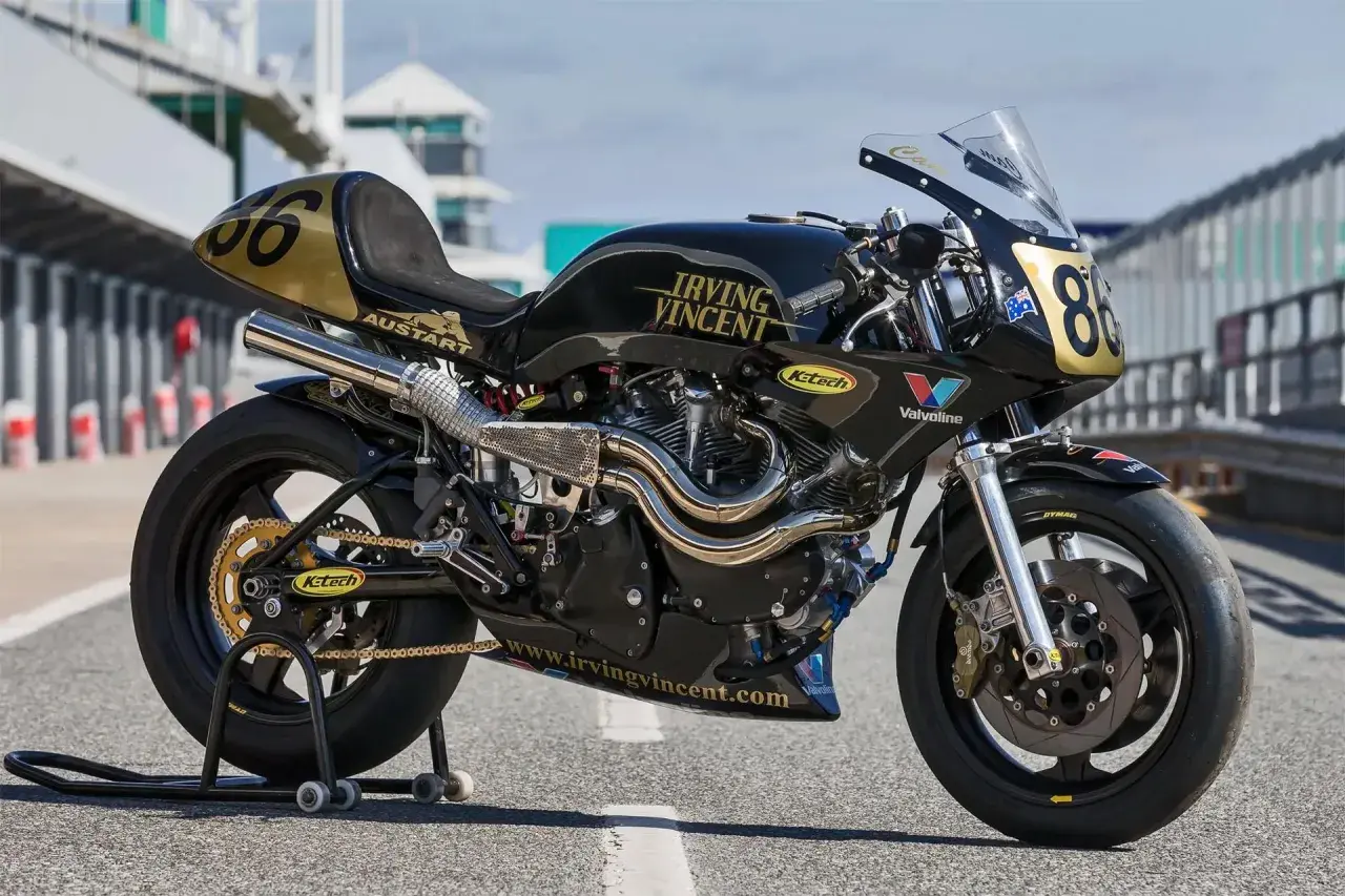 Motocicleta de carreras negra y dorada, modelo Irving Vincent, lista para la pista.