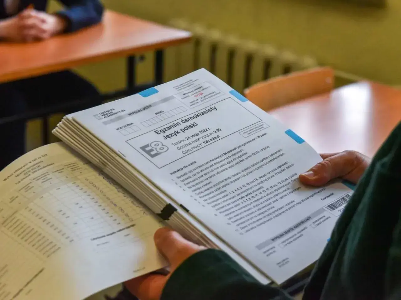 Stos arkuszy egzaminacyjnych z języka polskiego na egzaminie ósmoklasisty.