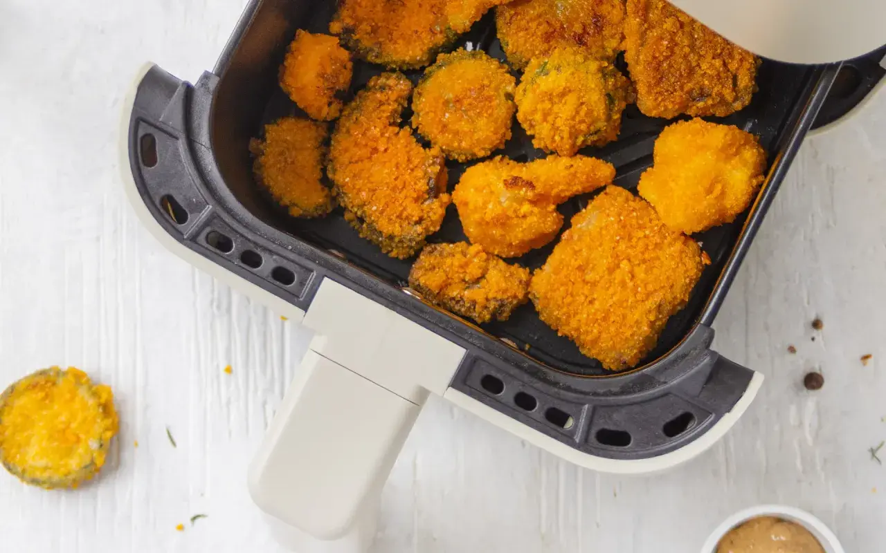Verdure in friggitrice ad aria, dorate e croccanti, pronte per essere gustate. Un'idea sana e veloce per uno snack o un contorno.