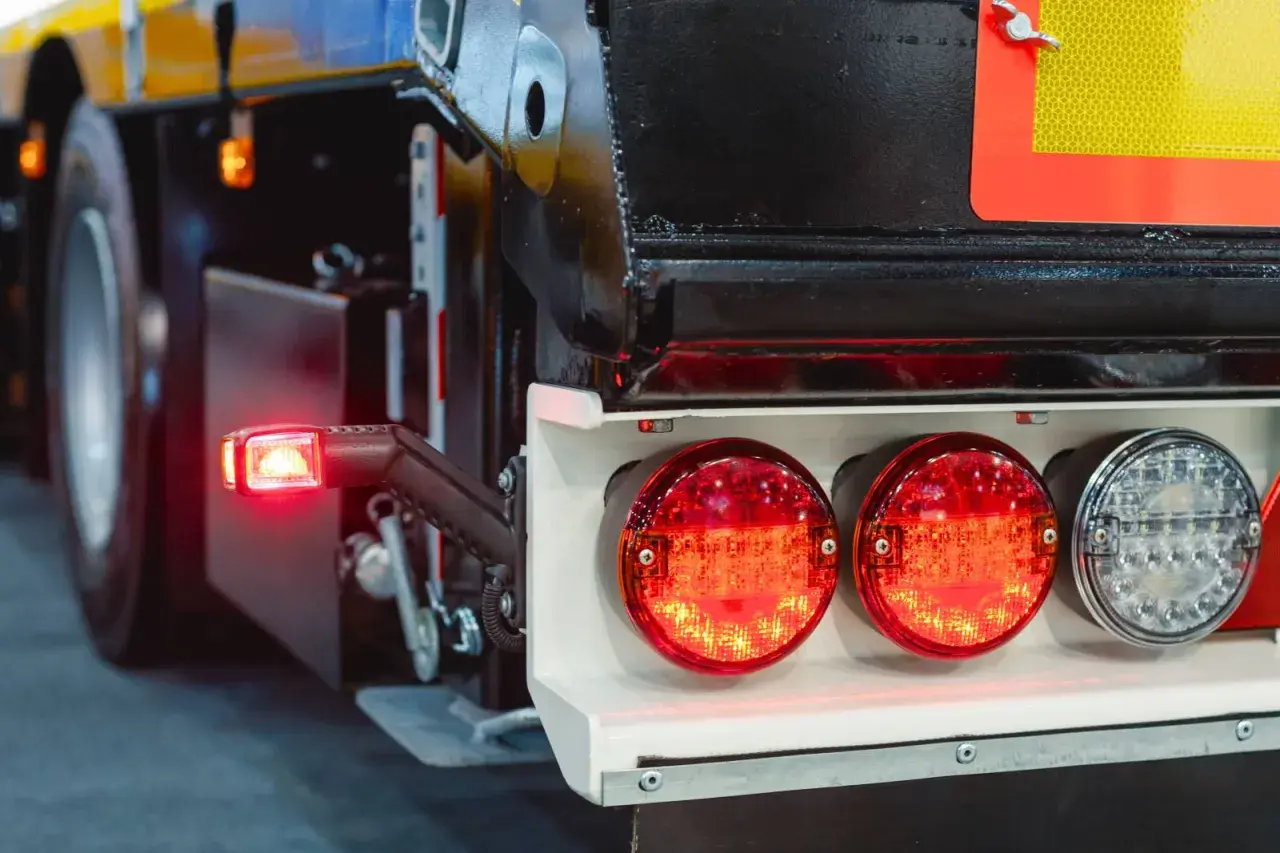 Feux arrière de camion, dont un clignotant rouge allumé. Le système de frein moteur est essentiel pour la sécurité.