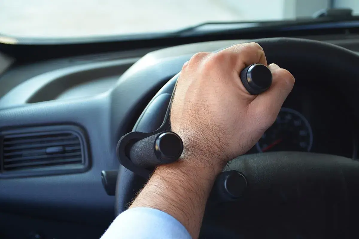 Mano con ausilio per sterzare, facilitando i comandi auto per chi ha difficoltà di presa.