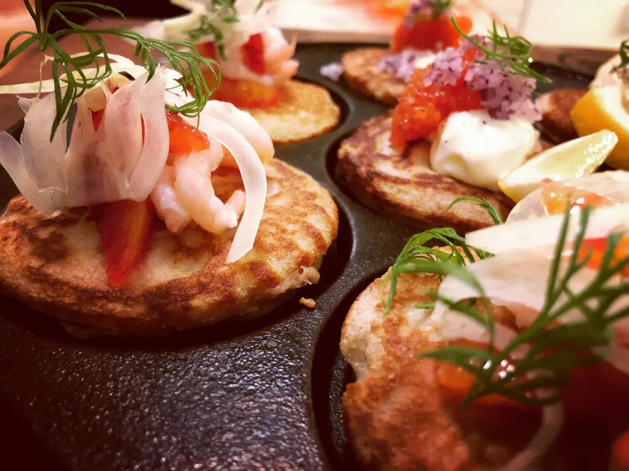 Små, gyllene blinier med räkor, dill och rödlök. Ett perfekt blinier recept för en festlig förrätt.
