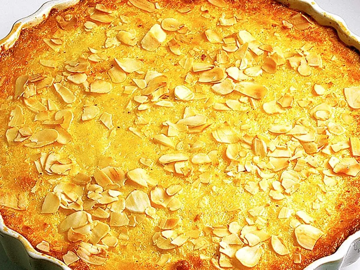 En gyllene ostkaka med mandelspån, perfekt för ett mysigt fika. Detta ostkaka recept är en klassiker!