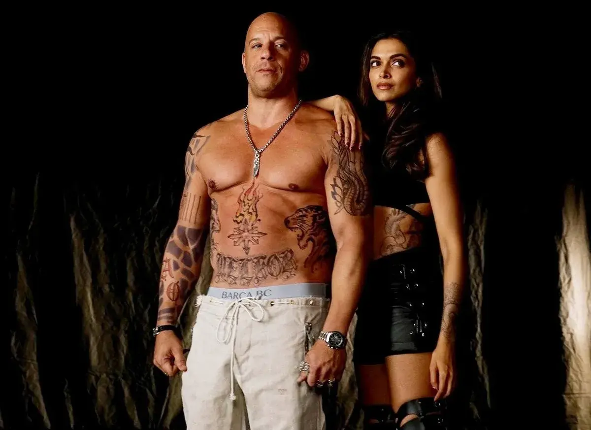 Vin Diesel med tatueringar och en kvinna i mörka kläder, en scen som påminner om hans filmer.