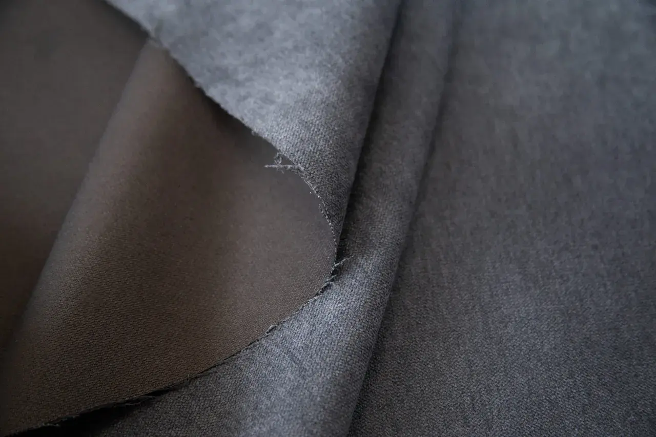 Szara tkanina soro, z jednej strony gładka, z drugiej lekko puszysta. Idealna na eleganckie ubrania.