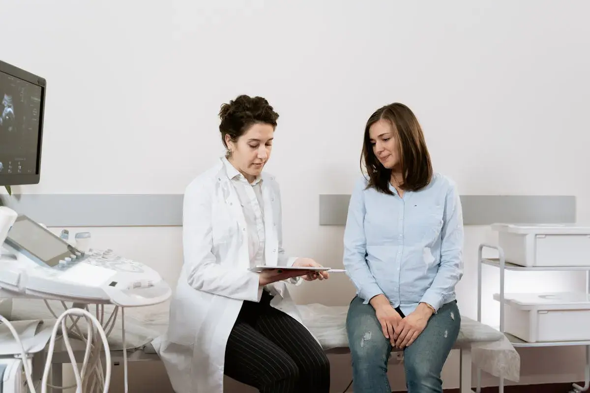 Medico spiega a paziente i risultati di un esame, forse un ecografia, discutendo del cerchiaggio cervicale.