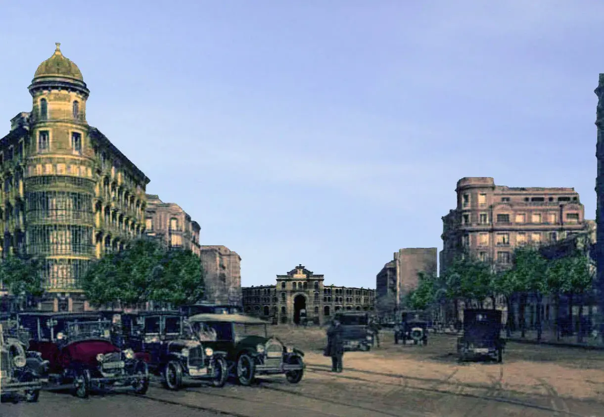 Vista de la antigua plaza de toros de Madrid, con edificios históricos y coches de época.