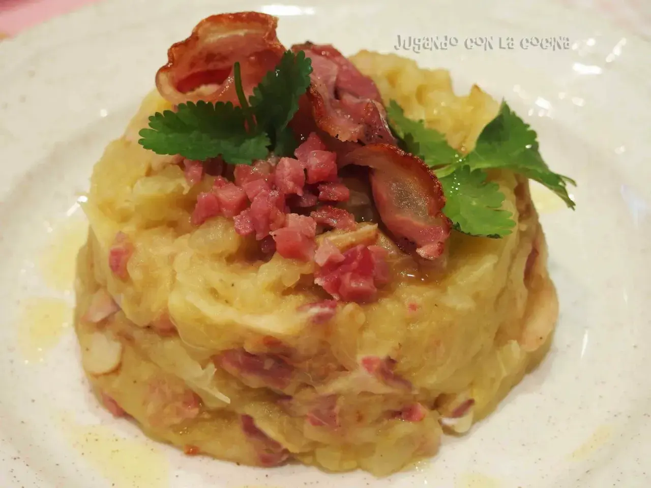Trinxat de la Cerdanya, un plato tradicional con patata, col y trocitos de tocino, coronado con bacon crujiente y perejil.