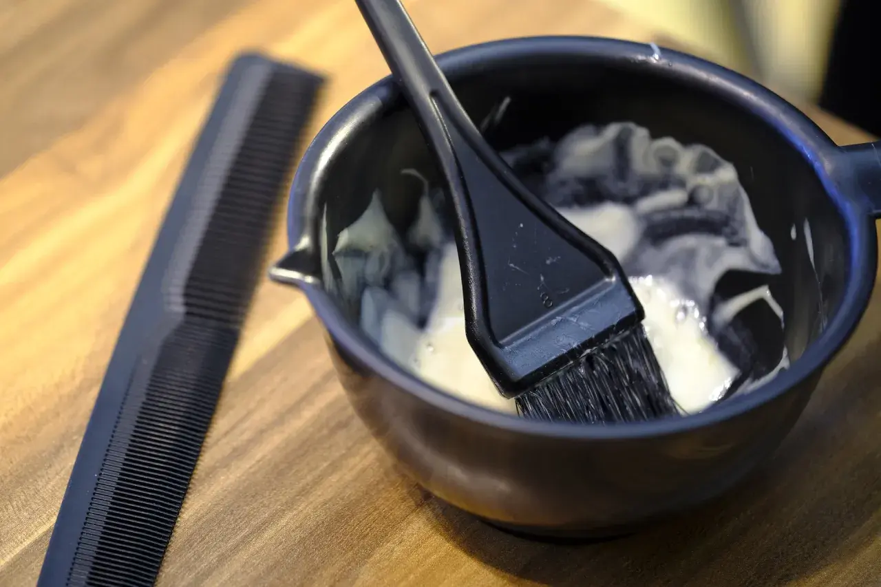 Mieszanka do farbowania włosów, jak do Casting Creme Gloss, gotowa do nałożenia na suche lub mokre włosy. Obok grzebień.