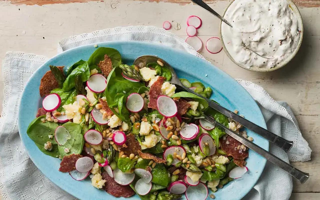 En härlig italiensk sallad med sparris, rädisor, salami och pinjenötter, serverad med en krämig dressing.