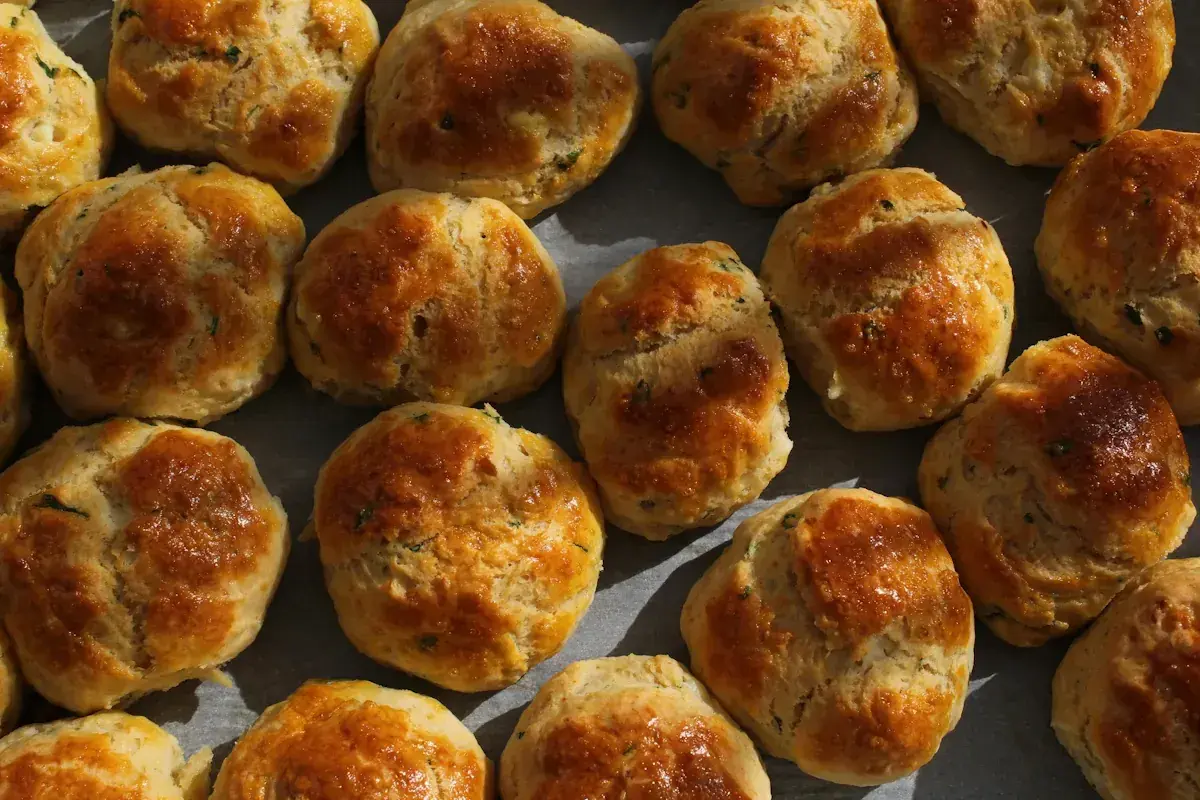 En person njuter av nybakade scones, gyllene och inbjudande.