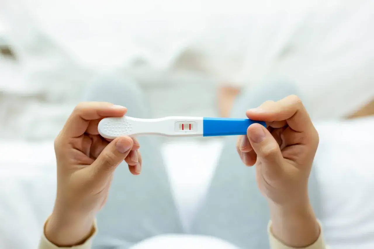 Deux barres rouges sur un test de grossesse, indiquant un résultat positif. Un test de grossesse qui ne fonctionne pas correctement peut causer de l'anxiété.
