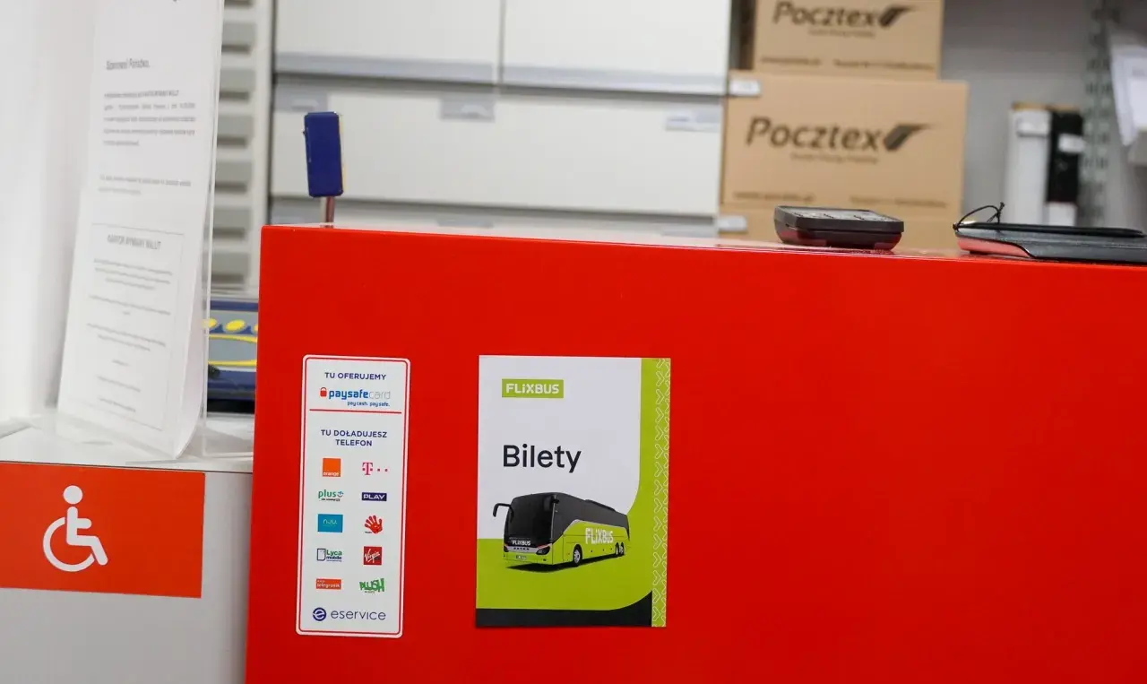 Na czerwonym blacie znajduje się plakat z napisem "Bilety Flixbus". Tutaj możesz kupić bilet na Flixbus.