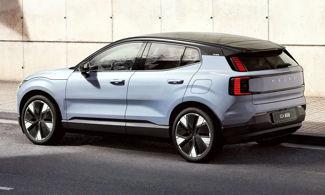 Nowy, elektryczny Volvo EX30 w kolorze jasnoniebieskim prezentuje się nowocześnie na tle betonowej ściany.
