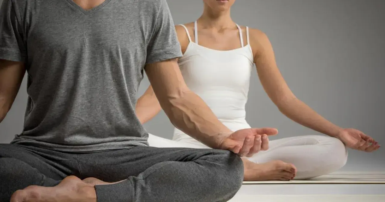 Para ćwiczy jogę kundalini w pozycji medytacyjnej.