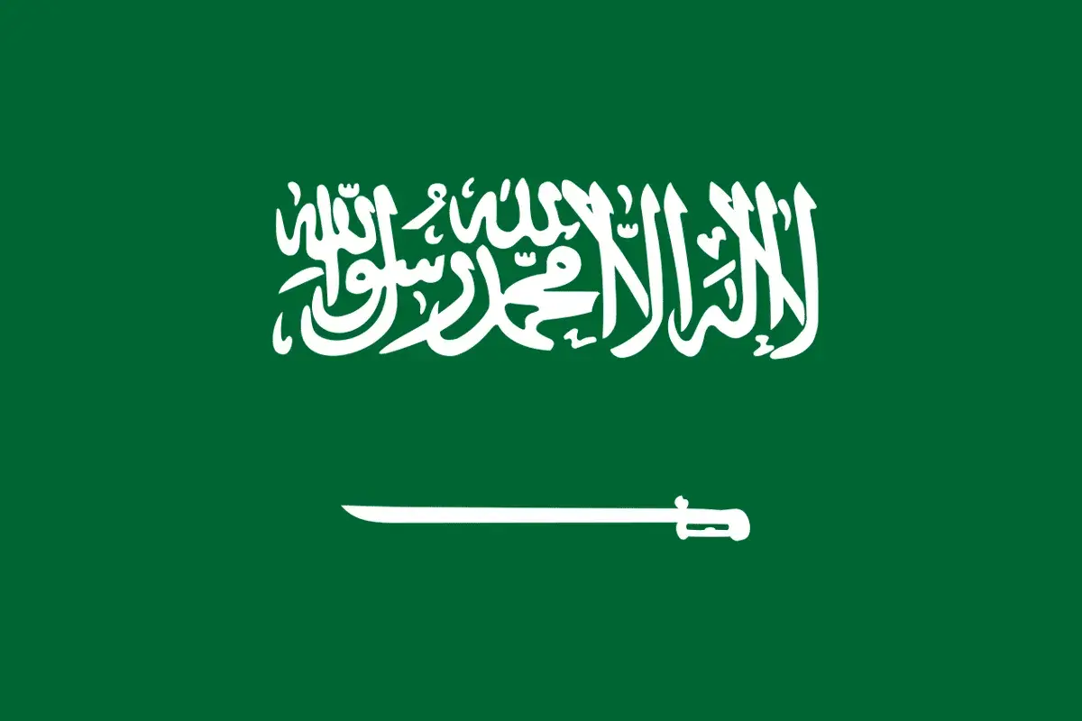 Flaga Arabii Saudyjskiej z napisem po arabsku i szablą. Planujesz podróż? Sprawdź wymagania dotyczące wizy do Arabii Saudyjskiej.