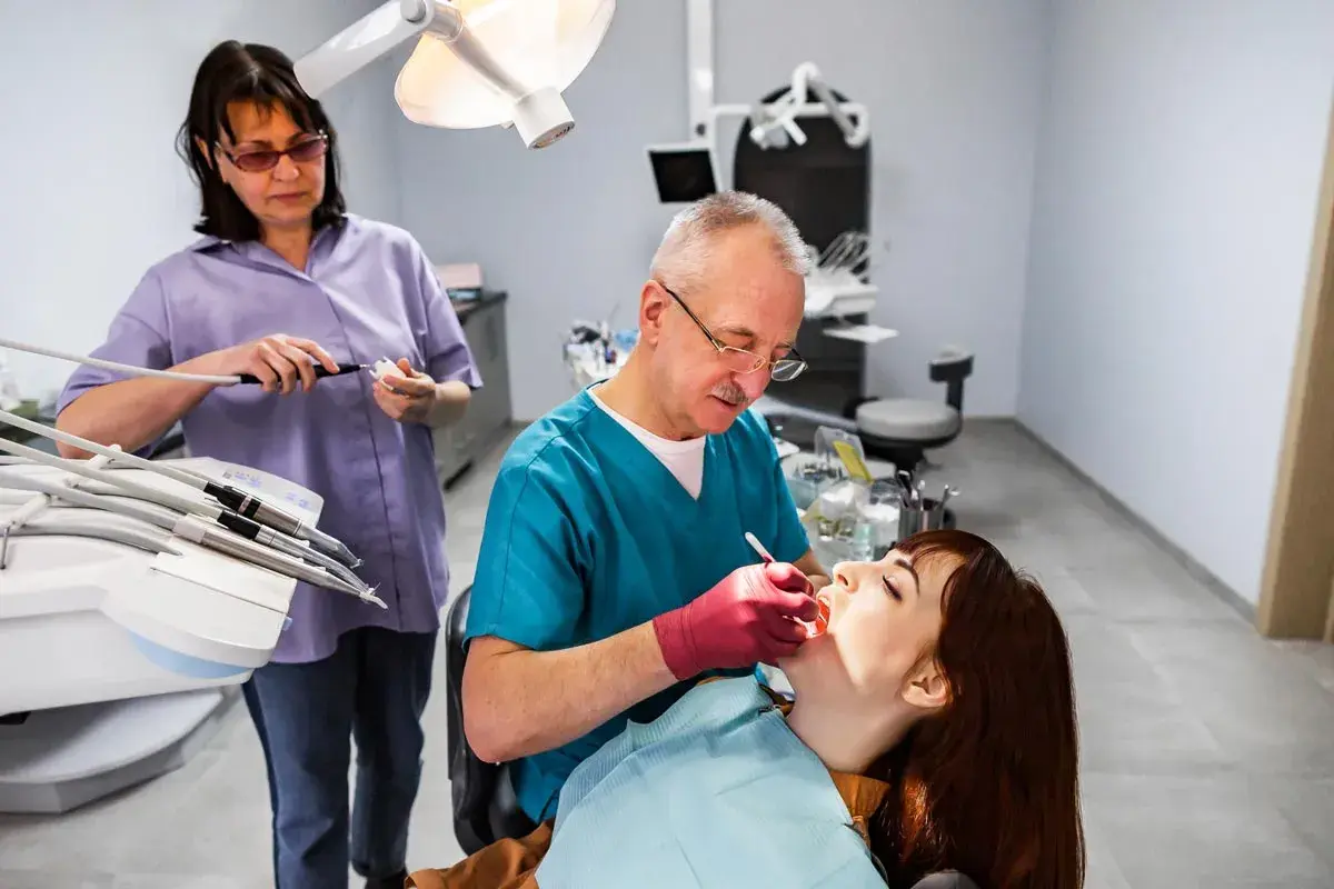 Dentista esamina una paziente. L'alitosi quando preoccuparsi? Chiedi al tuo dentista.