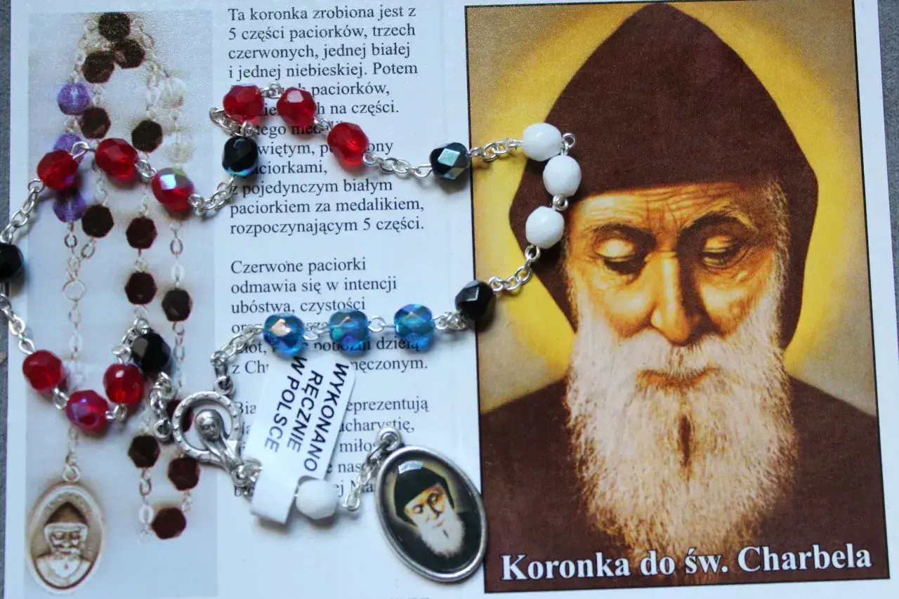 Koronka do św. Charbela, z kolorowymi paciorkami i medalikiem, obok wizerunku świętego. Idealna do odmawiania litanii do św. Charbela 9 dni.