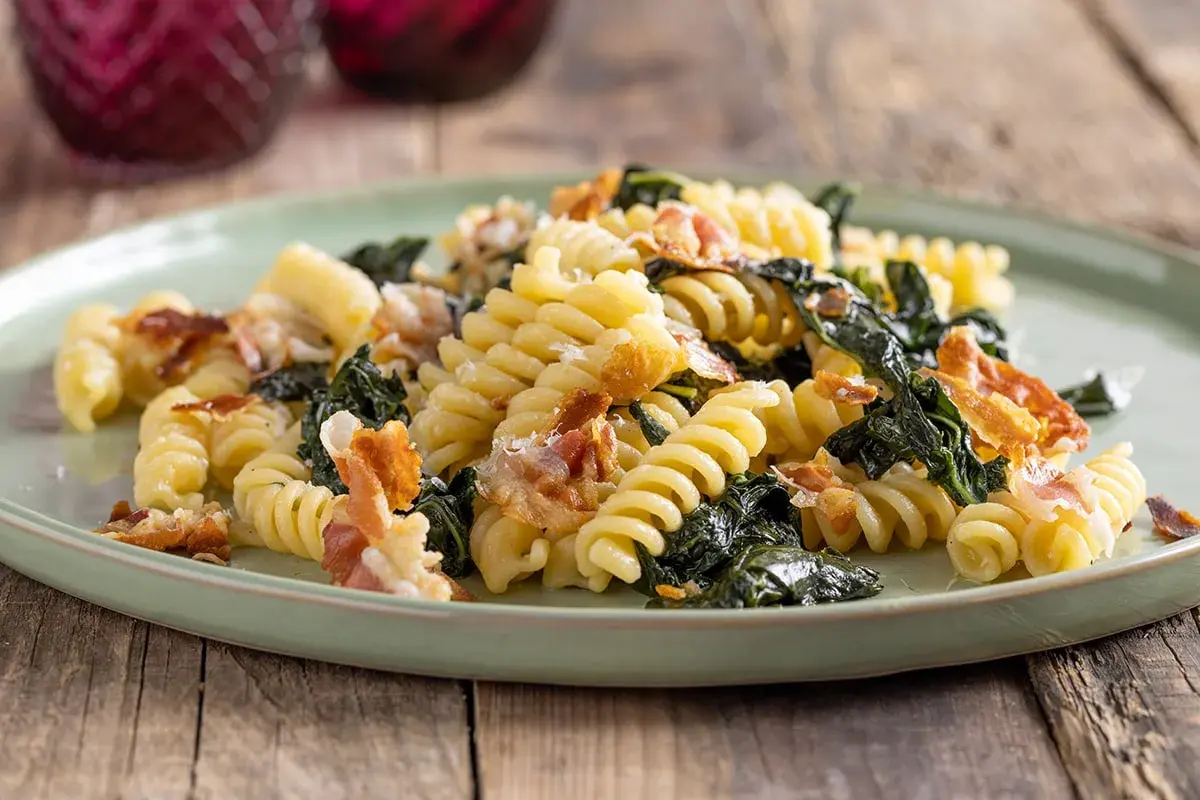 Fusilli con cavolo nero e pancetta croccante, un piatto semplice e gustoso che celebra i sapori della terra e della tradizione.