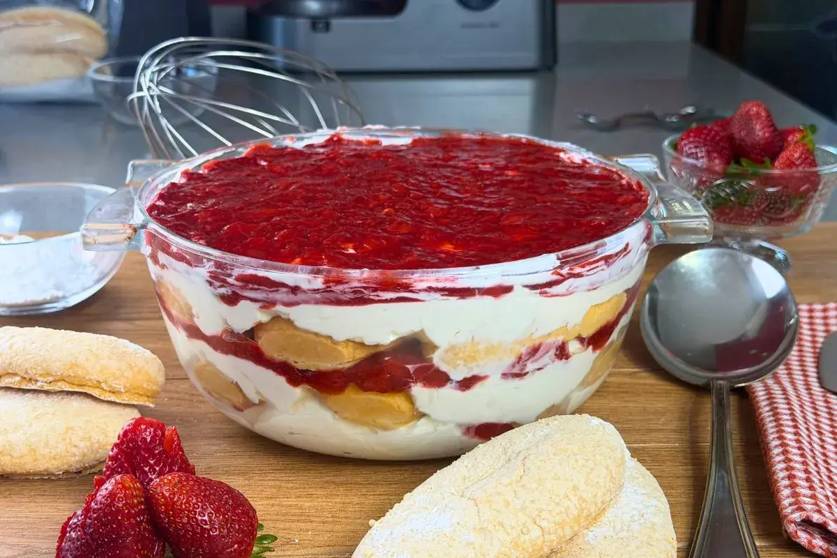 Un invitante tiramisù alle fragole in una ciotola di vetro, con savoiardi, crema e fragole fresche.