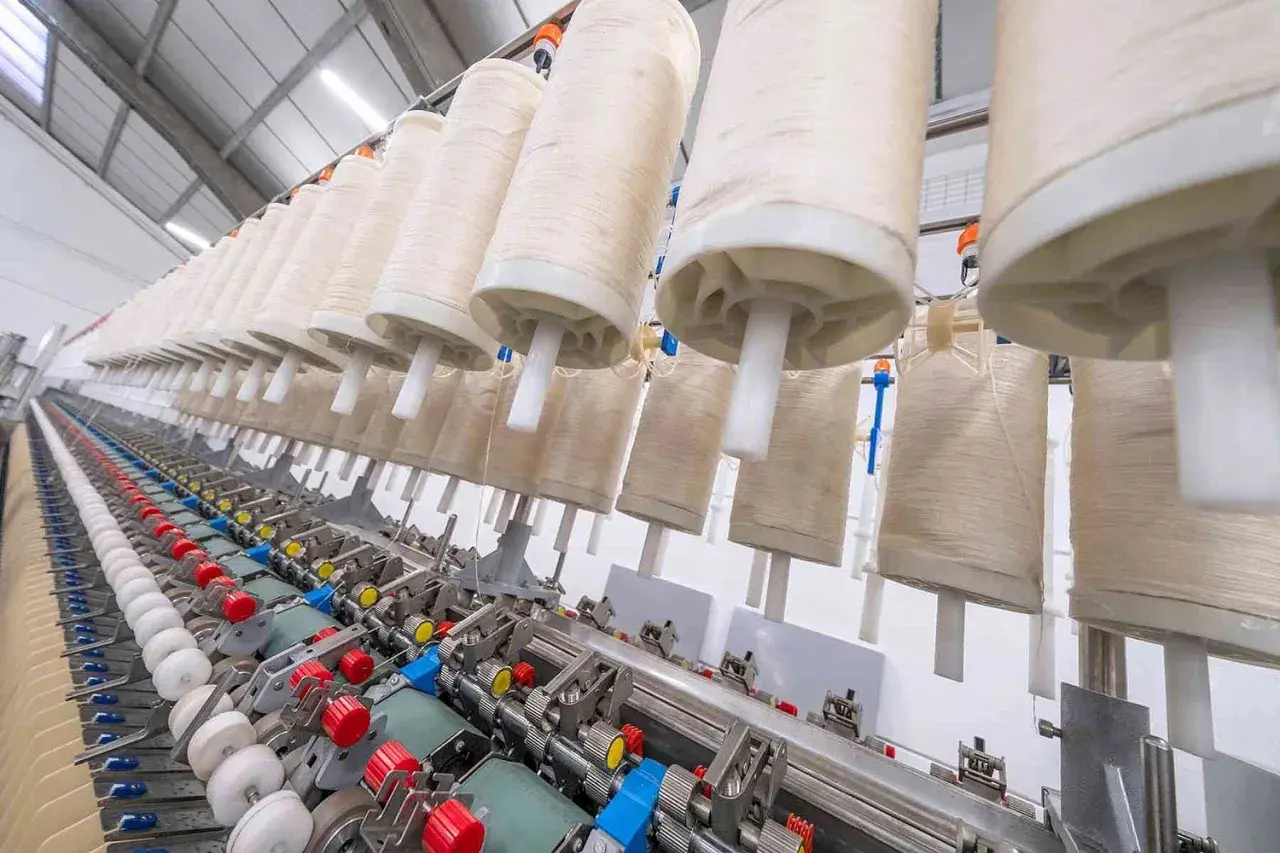 Machine à filer le lin en France, avec de grands rouleaux de fil prêts à être transformés.