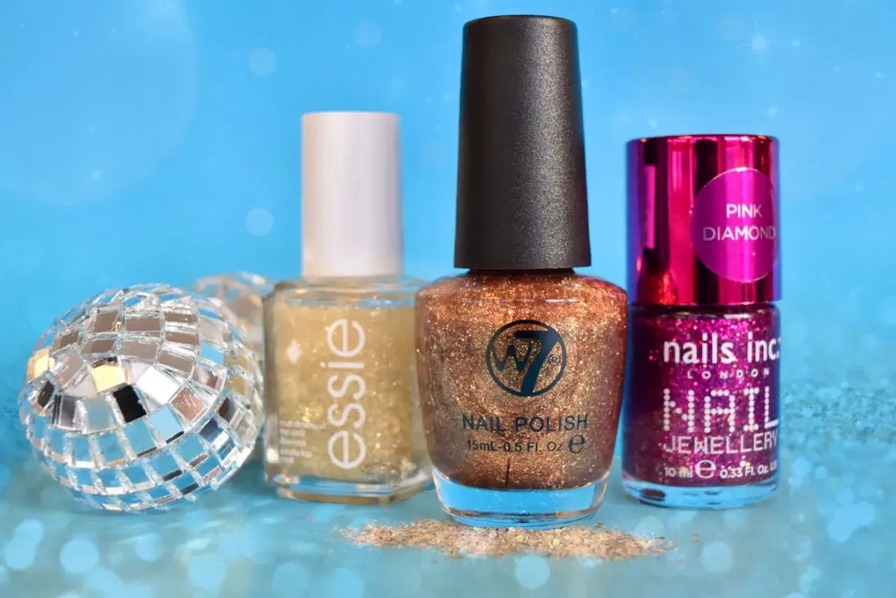 Glittrigt w7 nagellack i kopparfärg, bredvid Essie och Nails Inc. En discokula och glitter ger festlig känsla.