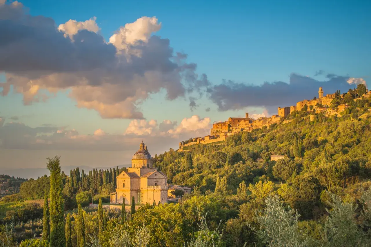 La chiesa rinascimentale e il borgo medievale, incastonati tra colline verdi, mostrano dove si trova Montepulciano al tramonto.