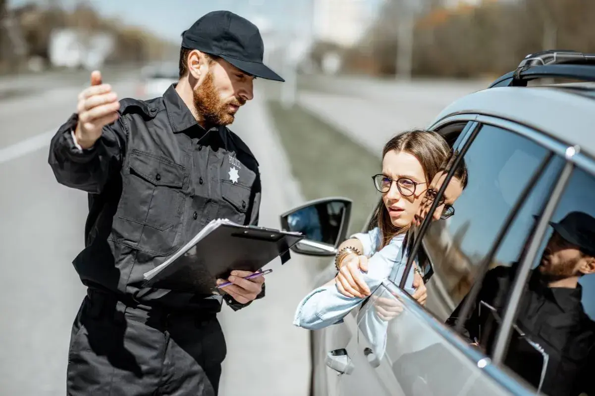 Policjant spisuje dane kierowcy. Zastanawia się, ile lat do policji potrzeba, by móc taką kontrolę przeprowadzać.