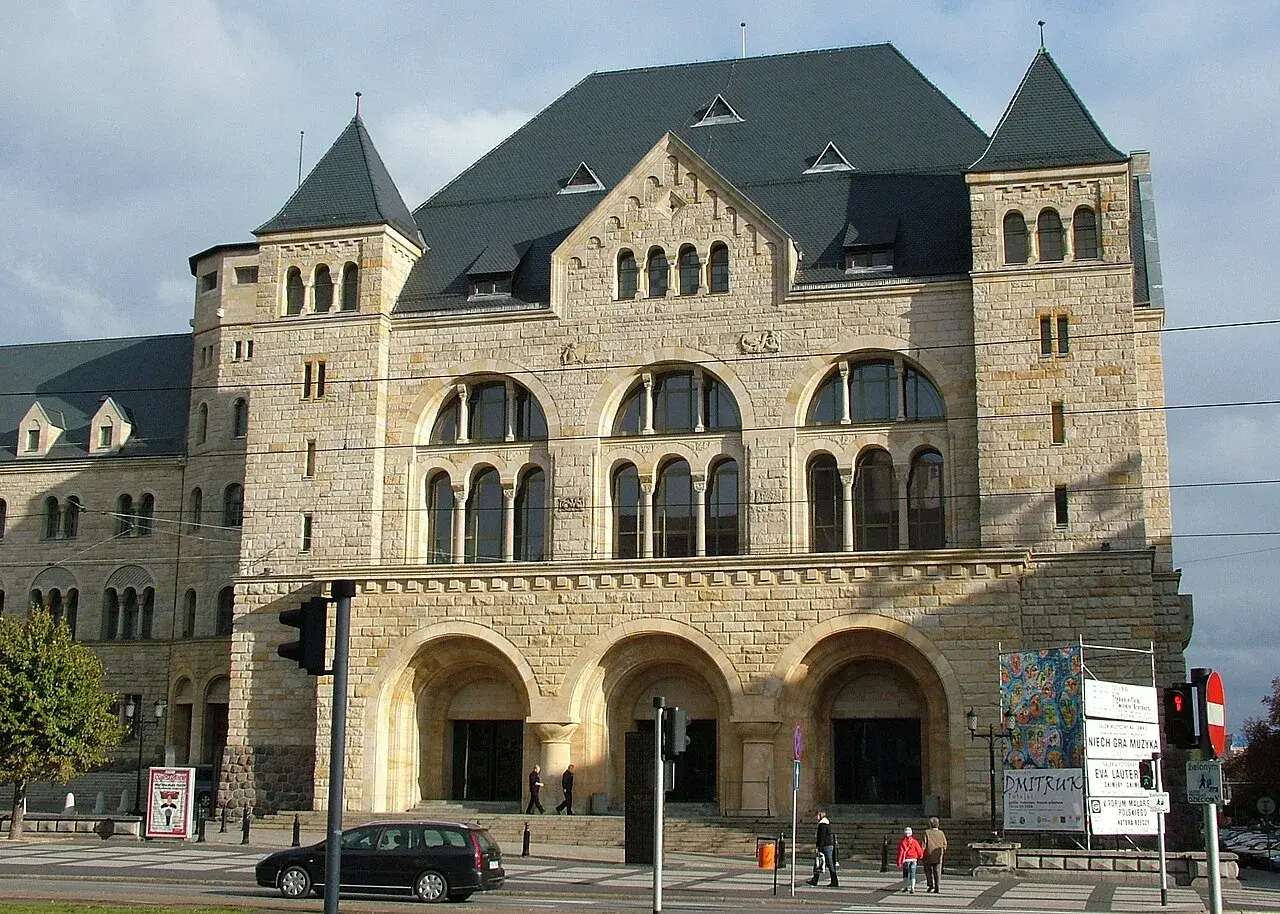 Imponujący zamek cesarski w Poznaniu, z kamienną fasadą i łukowymi oknami, przyciąga wzrok.