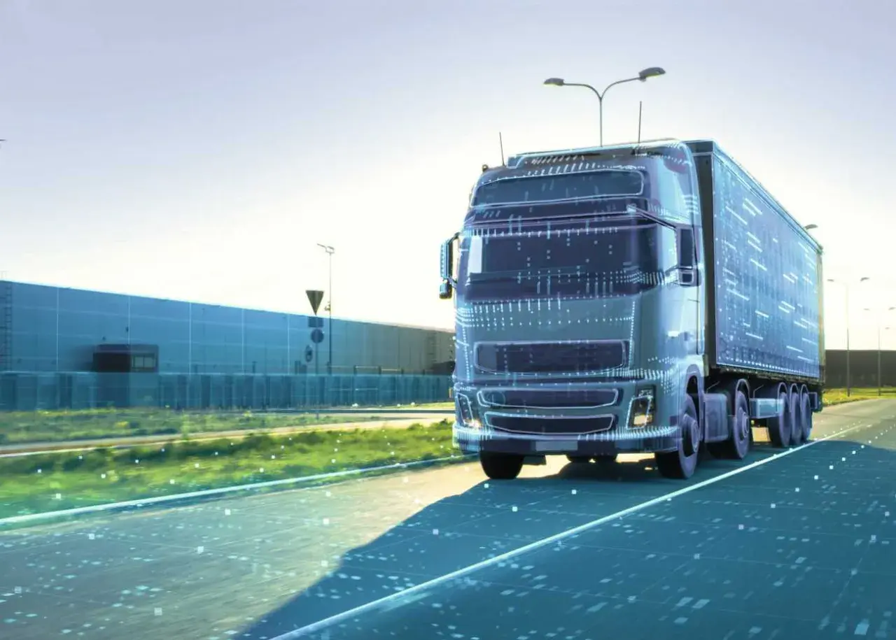 Ein futuristischer LKW fährt auf einer Straße, die von digitalen Daten durchzogen ist. Dies symbolisiert die Zukunft der Logistik und autonome Transportsysteme.