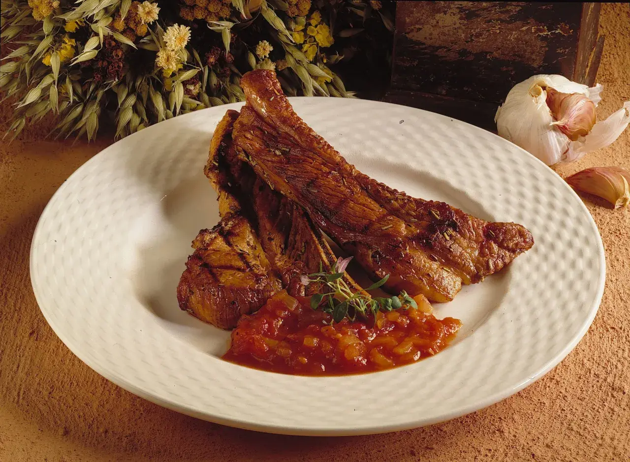 Saftiga spareribs i ugn, serverade med en smakrik tomatsalsa och garnerade med färska örter. En härlig måltid!